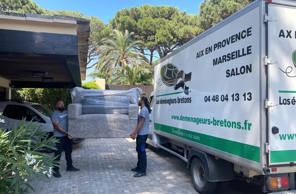 Chargement d’un canapé et d’autres meubles volumineux dans un camion de déménagement breton, près d’une villa. Déménagement pas cher.